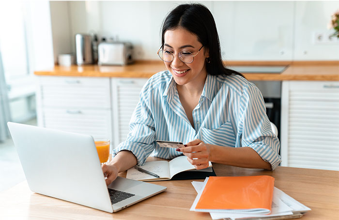 woman sitting at table with notebook and card 